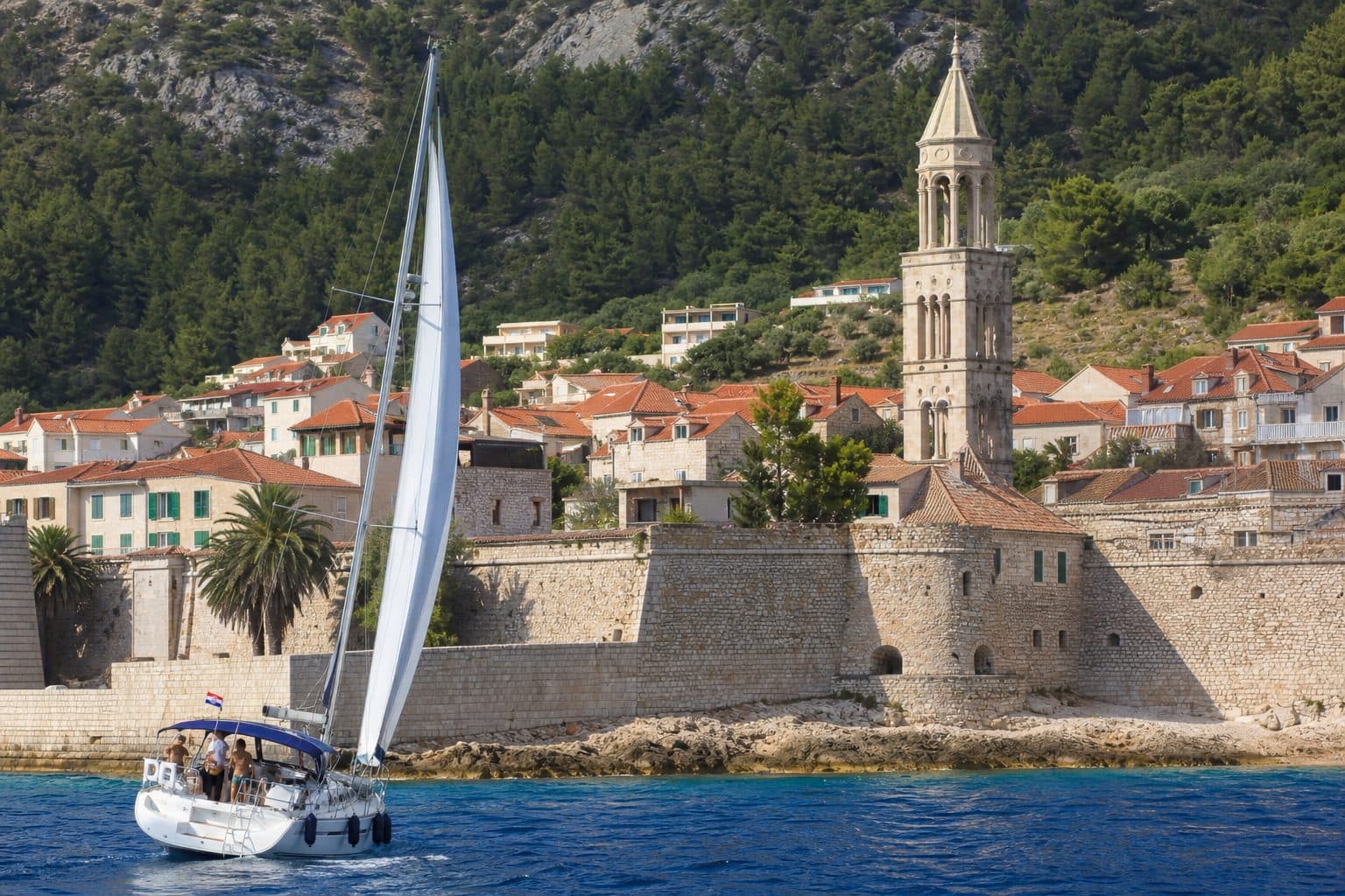 Voilier longeant les remparts de la vieille ville de Hvar